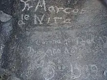 Inscription moderne apocryphe, gravée vers 1930 sur un rocher du Pima Canyon, en Arizona, souvent mais faussement attribuée à Frère Marc de Nice[1].