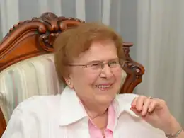 Portrait d'une femme âgée souriante, portant des lunettes