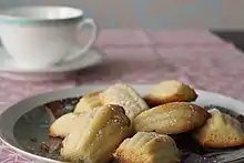 Assiette de madeleines devant une tasse de thé