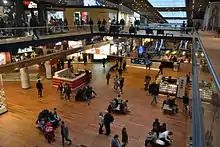 Photo de nombreuses personnes déambulant sur un sol façon parquet.