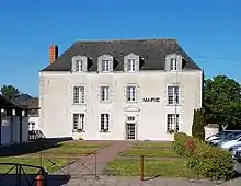 Photographie en couleurs d'un bâtiment à étage avec mention « MAIRIE » sur la façade.