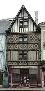  Photographie d'une façade de maison à colombages et pignon.