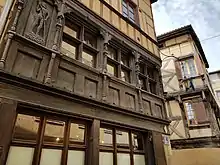 Photographie mettant en valeur la façade en bois sculpté de la maison de l'Homme des bois.