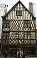  Photographie d'une façade d'une maison jumelle à colombages et pignon.