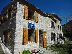 Deux maisons restaurées au Poil, dont l’une portant la bannière du Poil.