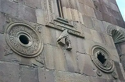 Détail de la façade sud : les deux oculi, la fenêtre centrale, une colombe sur un perchoir et la partie supérieure d'une des niches.