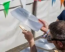 Pyrogravure sur bois à l'aide d'une lentille de Fresnel.