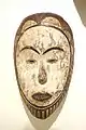 masque figurant un visage humain stylisé, fait de bois recouvert de kaolin