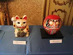 Un maneki-neko avec une autre figurine porte-bonheur : le daruma.