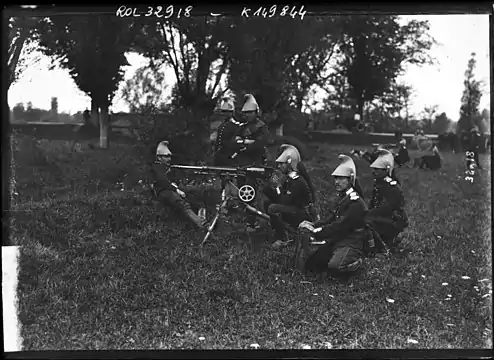 Photo en noir et blanc d'un groupe de cinq soldats autour d'une arme.