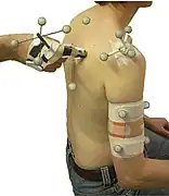 La palpation vraie (manuelle) peut être commbinée à une palpation virtuelle (modèle 3D informatique, ici d'un genou, avec "points clés" anatomiques).