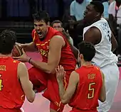 Marc Gasol, le ballon dans les mains, avec Kevin seraphin dans son dos, et deux coéquipiers, de dos, face à lui.