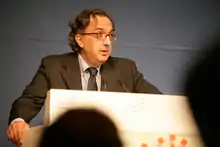 Photo de Sergio Marchionne, parlant à une tribune, devant un public