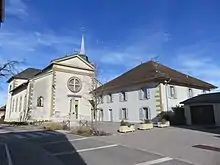 Photographie en couleurs de l’église et du presbytère.