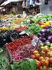 L'étal d'une marchande de fruits et légumes dans un marché couvert à Gênes.