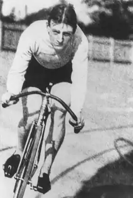 Photographie en noir et blanc d'un homme chevauchant une bicyclette.