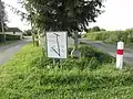 Croix au hameau La Cohue, avec un panneau indicateur de plusieurs lieux-dits de la commune.