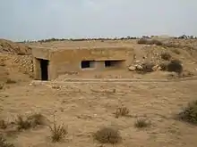 photo en couleurs d'un petit bunker émergeant des sables