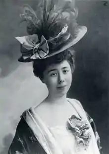 Portrait photographique en noir et blanc d'une jeune femme coiffée d'un chapeau chargé de décorations