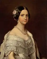la princesse représentée en buste porte une robe en satin bleu pâle et une fleur dans ses cheveux noirs séparés en bandeaux