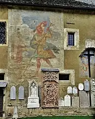 Fresque de saint Christophe avec une partie du lapidarium.