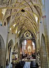 La nef vers le chœur et l'abside. Le plafond comporte des fresques illustrant la généalogie de Jésus.