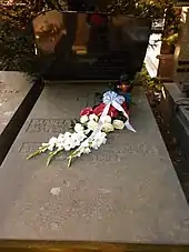 Photographie de la tombe de Marian Rejewski avec un bouquet de fleurs posé sur la stèle.