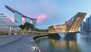 Panoramique de l'hôtel Marina Bay Sands et bâtiment éclairé Louis Vuitton à Marina Bay le soir avec des nuages roses, à Singapour. Juin 2018.