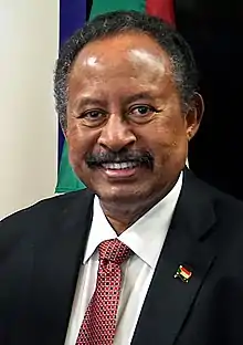 Homme africain souriant en costume et cravate, de face