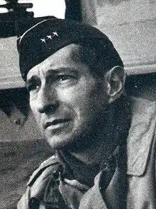 Portrait en noir et blanc trois quarts face d'un soldat portant un béret militaire décorée de 3 étoiles en ligne