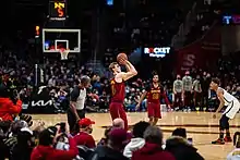 Un joueur de basket-ball en train de tirer à trois points.