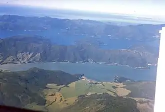 Photographie aérienne de deux rias parallèles séparées par des collines boisées.