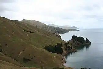 Photographie couleur d'une pente dénudée plongeant dans la mer.