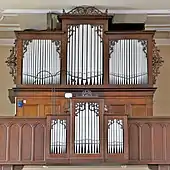 Photographie d'un orgue de tribune à l'intérieur d'une église.