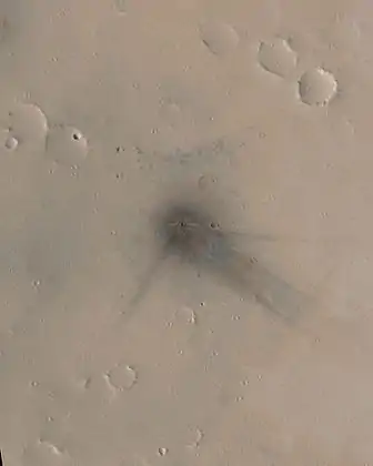 L'apparition de ce cratère d'impact photographié par MGS et situé dans Ulysses Patera a pu être datée entre le 18 avril 2003 et le 7 février 2004. Son diamètre est de 19,8 ± 3 mètres.