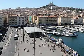 Le quai, l'ombrière du Vieux-Port et la « Bonne Mère » qui domine la ville.