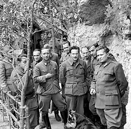 Un groupe d'hommes en uniforme, avec une roche en arrière-plan.