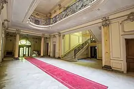 Le magnifique hall paré de faux marbre jaune.