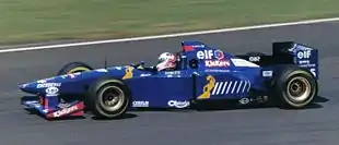 Photo d'une monoplace de Formule 1 bleue sur un circuit, vue de profil gauche.