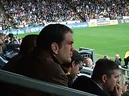 Photo de Martin Johnson assis dans les tribunes de l’Adams Park.