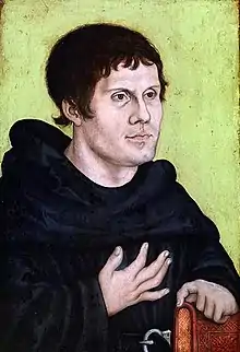 Peinture représentant un homme vu en buste, vêtu d'une robe de bure et tenant un livre sous sa main gauche