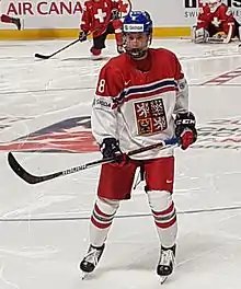 Photographie d'un joueur de hockey sur glace avec un uniforme rouge, blanc et bleu.