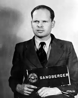 Martin Sandberger (1911-2010), ancien commandant du sonderkommando 1a de 'Einsatzgruppe A', ayant été actif dans l'extermination des Juifs des États baltes puis en Italie, organisant la déportation des Juifs vers Auschwitz.