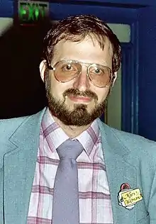 photo en couleur d'un homme avec des lunettes et une barbe