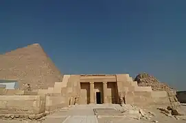 Entrée du mastaba du haut dignitaire Seschemnefer (fin IVe-début Ve dynastie), à Gizeh ; la pyramide de Khéops en arrière-plan.