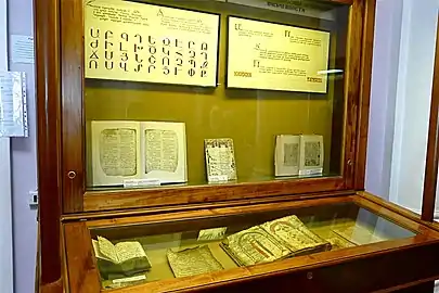 Vitrine d'exposition contenant divers manuscrits et affiches explicatives.