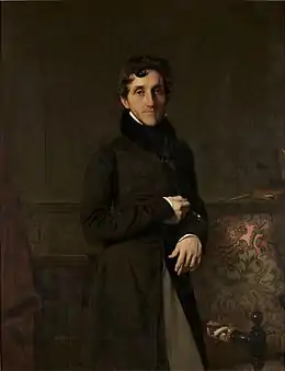 Portrait d'un fonctionnaire du Premier Empire : vêtu d'une redingote noire, celui-ci est debout, accoudé au dossier d'un fauteuil, le regard détaché, l'air serein.
