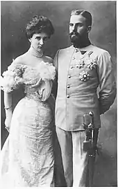 Photographie en noir et blanc d'un couple dont l'épouse porte une ample robe claire et le mari un uniforme d'officier autrichien.