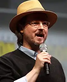 Un homme avec des lunettes et un chapeau.