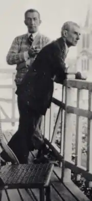 photographie noir et blanc de deux hommes au balcon.